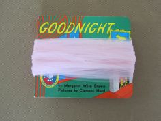 there is a card with some pink yarn on it and the words goodnight written in yellow