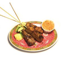 a plate with some food on it and two chopsticks sticking out of the meat