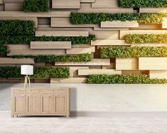 an empty room with green plants growing on the wall and concrete flooring in front of it