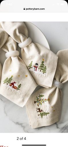 four embroidered christmas tree napkins on a plate