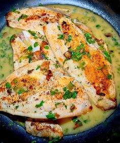 some chicken is cooking in a pan with broccoli and sauce on the side