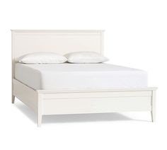 a white bed with two pillows on top of it