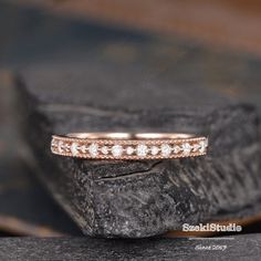 a close up view of a wedding ring on top of a piece of rock,