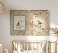 two framed pictures hang above a crib in a baby's room with a bird theme