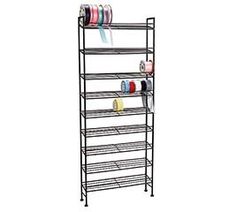 a metal shelf with several shelves and cups on top of it, all stacked up against the wall