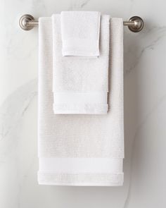 two white towels hanging on a towel rack