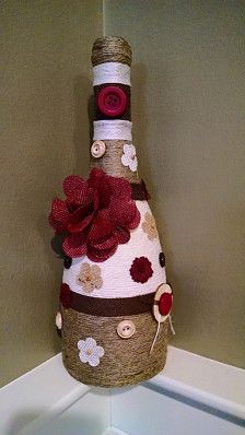 a wine bottle is decorated with flowers and burlocks on the top of it