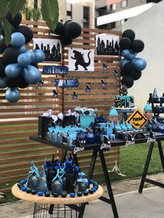 a table that has some balloons on it and blue decorations around the tables in front of it