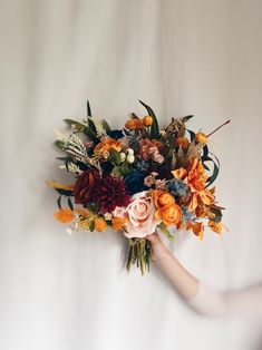 a woman holding a bouquet of flowers in her hand