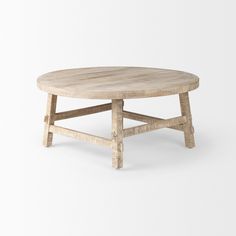 a round wooden table sitting on top of a white floor