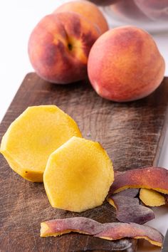 two pieces of fruit sitting on top of a cutting board next to another piece of fruit