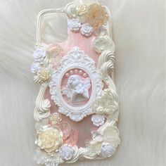 an iphone case is decorated with flowers and pearls on a white furnishing surface