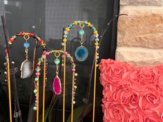 three decorative items sitting on top of a window sill next to a red rose