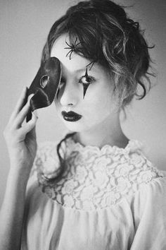 a woman with makeup on her face holding a phone