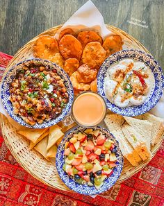 a plate full of different types of food on a red and blue table cloth next to a glass of orange juice