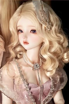 a close up of a doll with blonde hair