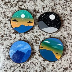 three painted wooden discs sitting on top of a granite counter next to a bottle opener