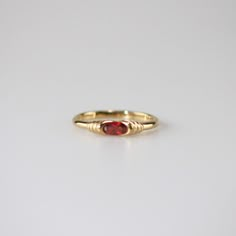 This exquisite Garnet Slim Ring features a vibrant red gemstone at its center, encased within a setting that beautifully highlights its rich color and sparkle. The band is elegantly adorned with intricate patterns. This stunning ring is perfect for special occasions or everyday wear, and makes a beautiful addition to any collection. 18k gold plated Stainless steel base Waterproof and tarnish free Available in US 6-8 Ring sizing chart Elegant Red Gemstone Stackable Rings, Elegant Red Garnet Stackable Rings, Ruby Crystal Ring For Promise, Elegant Red Stackable Promise Rings, Elegant Stackable Garnet Gemstone Rings, Elegant Garnet Gemstone Stackable Rings, Elegant Garnet Stackable Rings, Red Birthstone Stackable Rings Fine Jewelry, Fine Jewelry Red Birthstone Stackable Rings