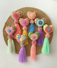 a group of colorful tassels hanging from a woven wall hanger on a white wall