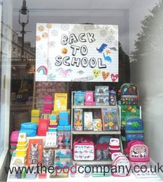 the back to school sign is displayed behind a display case filled with books and toys