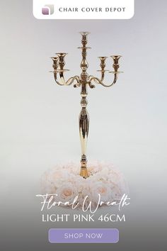 a gold candelabra with three candles on it and flowers in the middle