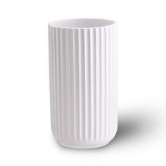 a white vase sitting on top of a table