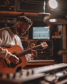 a man playing an acoustic guitar in a recording studio