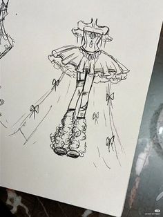 a drawing of a dress and boots on a piece of paper next to a camera