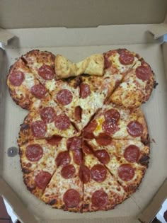 a mickey mouse shaped pizza in a box with slices missing from the toppings on it