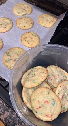 some cookies are in a plastic container on the stove