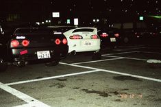 two cars parked in a parking lot at night