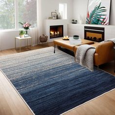 a living room filled with furniture and a fire place next to a large window on top of a hard wood floor