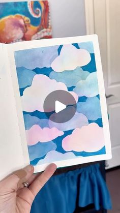 someone is holding up a card with clouds on it