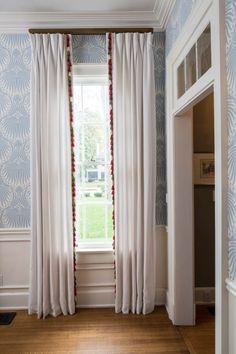 an empty room with blue and white wallpaper