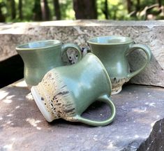 two green cups sitting on top of a stone slab