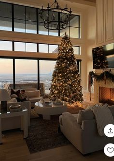 a living room filled with furniture and a christmas tree in front of a large window