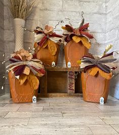 three pumpkin shaped planters with bows on them