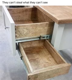 an open drawer on the side of a desk that is being used as a workbench