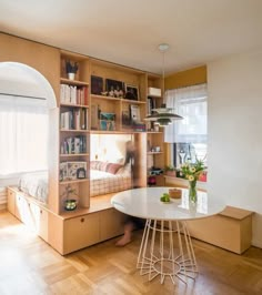 a room with a bed, desk and shelves