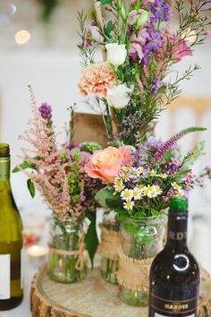 flowers in vases and wine bottles on a table with text that reads lovemy dress net