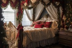 a bedroom decorated for christmas with red and white decorations on the bed, windows, and curtains