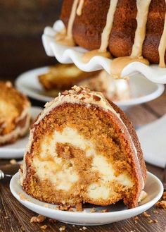 two bundt cakes on plates with one being cut in half and the other is topped with icing