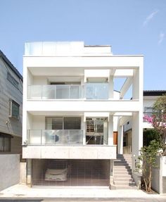 a large white building with stairs leading up to it's second floor and two levels