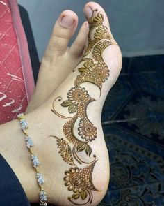 a woman's foot with henna tattoos on it