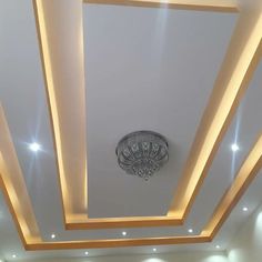 a ceiling with lights and chandelier in a room that is empty except for people to see