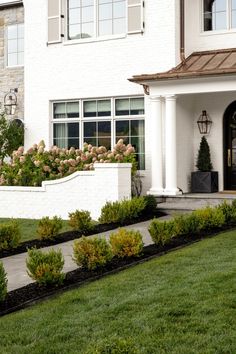 a white house with landscaping in front of it