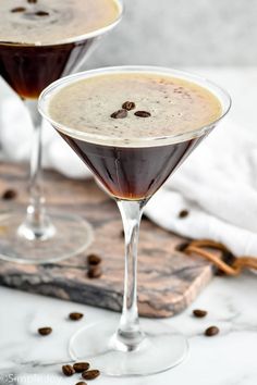 two glasses filled with liquid and coffee beans