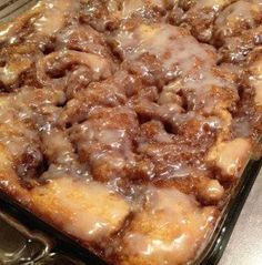 a cinnamon bun cake with icing on top in a pan, ready to be eaten