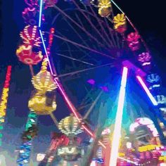 the ferris wheel is brightly lit up at night