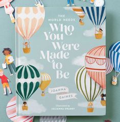 there is a children's book with hot air balloons on the cover and paper cutouts around it